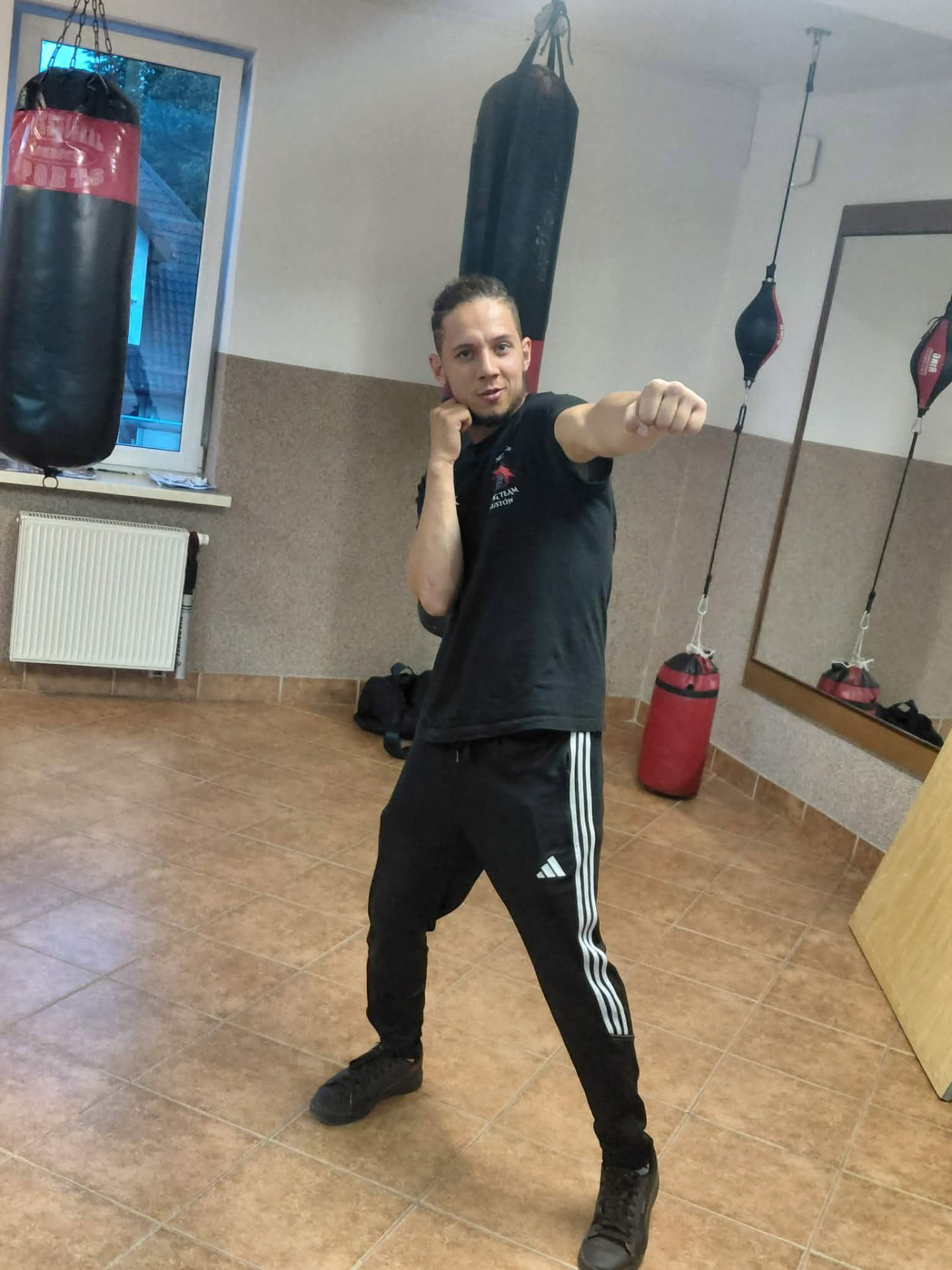 Kuba pokazuje technikę ciosu na sali treningowej